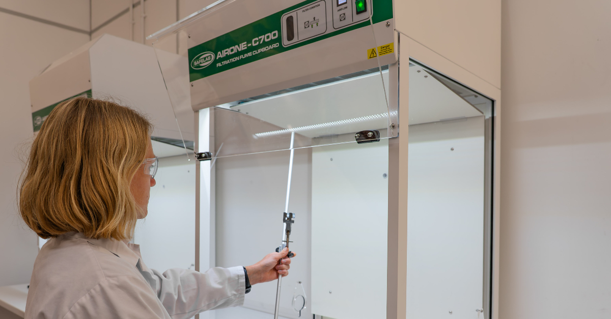 Female lab technician putting clamp inside C700 fume cabinet